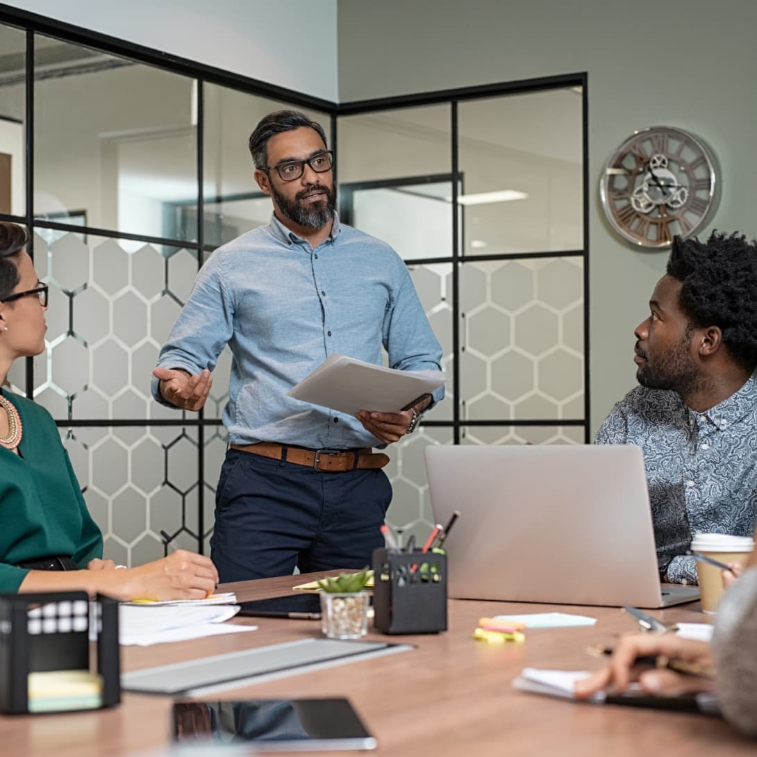 professionals in a meeting room discussing medication review for a health plan member